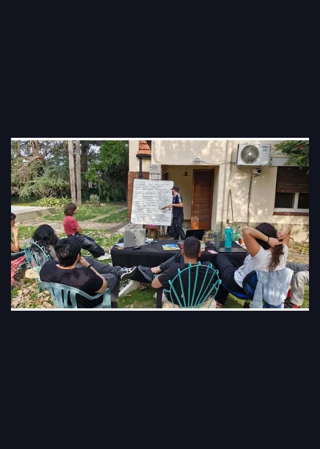 Clase al aire libre con pizarra y alumnos